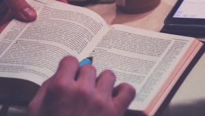 A person reading a Bible at a table.