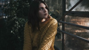 A young woman looking out a window.