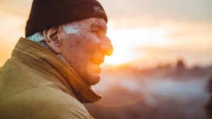 An older man with the sun behind him.