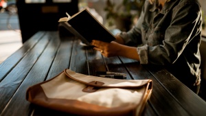 A woman reading a book at a table.