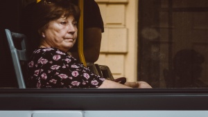 A women looking outside the window of a bus.