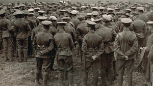 An old WWI photograph showing a church service in the field with soldiers watching a priest.