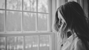 A young woman looking outside a window.