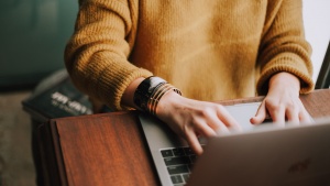 A woman typing on a laptop.