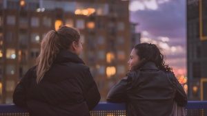 Two young women talking to each other.