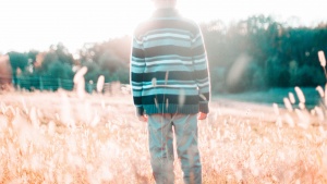 A young boy standing in a field.