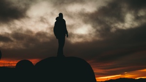 A man standing on a boulder.