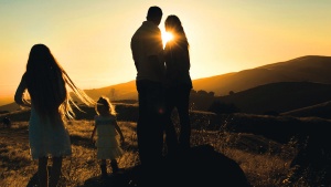 A family in a field at sunset.