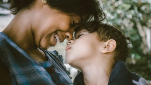 A mother and child touching foreheads. 