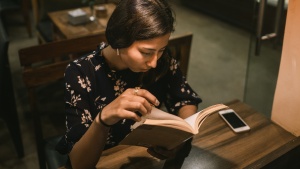 A woman reading a book in a cafe.