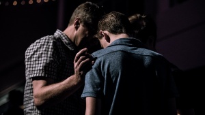 Two men praying together.