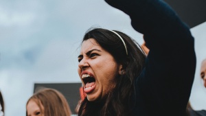 An angry woman screaming with her fist in the air.