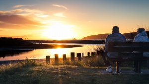 Two people sitting on a bench.