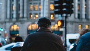 A older man at busy sidewalk.