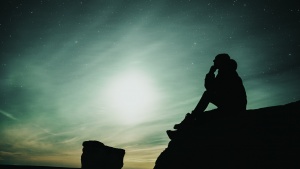 A man sitting on a rock.