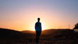 A young man watching the sun set.