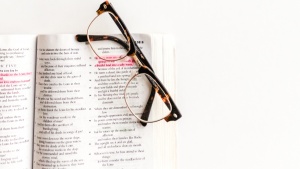 Photo of glasses sitting atop an open Bible.