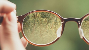 A person holding a pair of glasses.