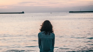 A young woman looking out at a body of water.