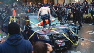 Rioters destroy a police vehicle in Seattle.