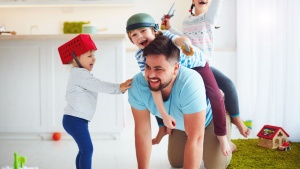 A dad playing with his kids.