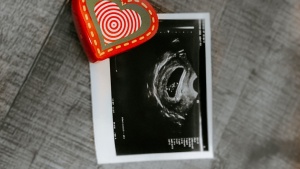 An ultrasound photo with a red heart next to it