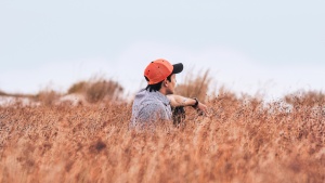 A young man sitting in a field.