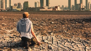 A person sitting on dry barren dirt.