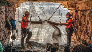 Israeli archeologists Hagay Hamer and Oriah Amichai sift dirt at a cave in the Judean Desert where addtional ancient scroll fragments were found.