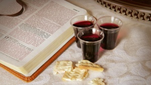 An open Bible with Passover wine an pieces of unleavened bread.