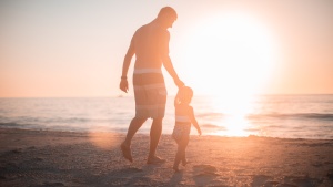 A father and child walking on the beach