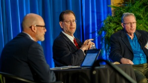 Three men giving a panel presentation