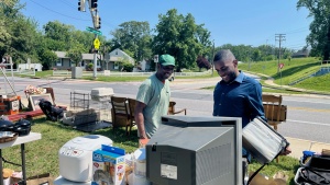 Two men examining items at a yard sale