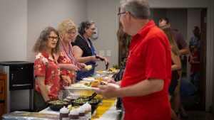 home office employees on both sides of a food serving line