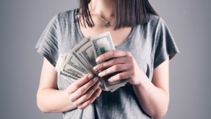 a woman holding one-hundred dollar notes