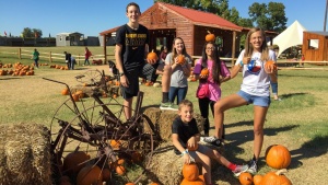 a group of young people with pumpkins