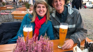 a couple seated outdoors with beers