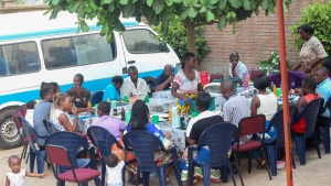 a group of people eating outdoors in front of a van