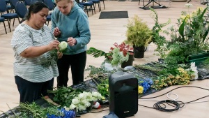 two ladies assembling floral arrangements