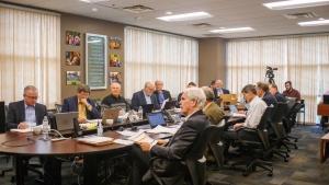 Council of Elders members seated at a table for a meeting