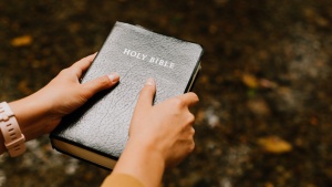 A person holding a Bible.