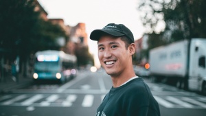 a smiling man with a city street background