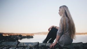 A young woman looking over water.