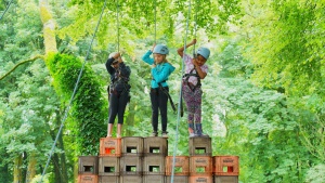 a group of children in climbing harnesses standing on some stacked crates