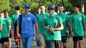 a group of teenage boys and their counselors walking outdoors