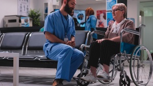 A doctor talking with a patient in a wheelchair. 