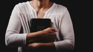 A woman holding a Bible.