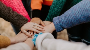 several hands extended to meet one another in a circle