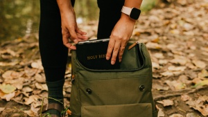 A person pulling their Bible out of the backpack. 