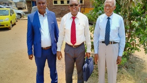 three men standing outside in front of a building